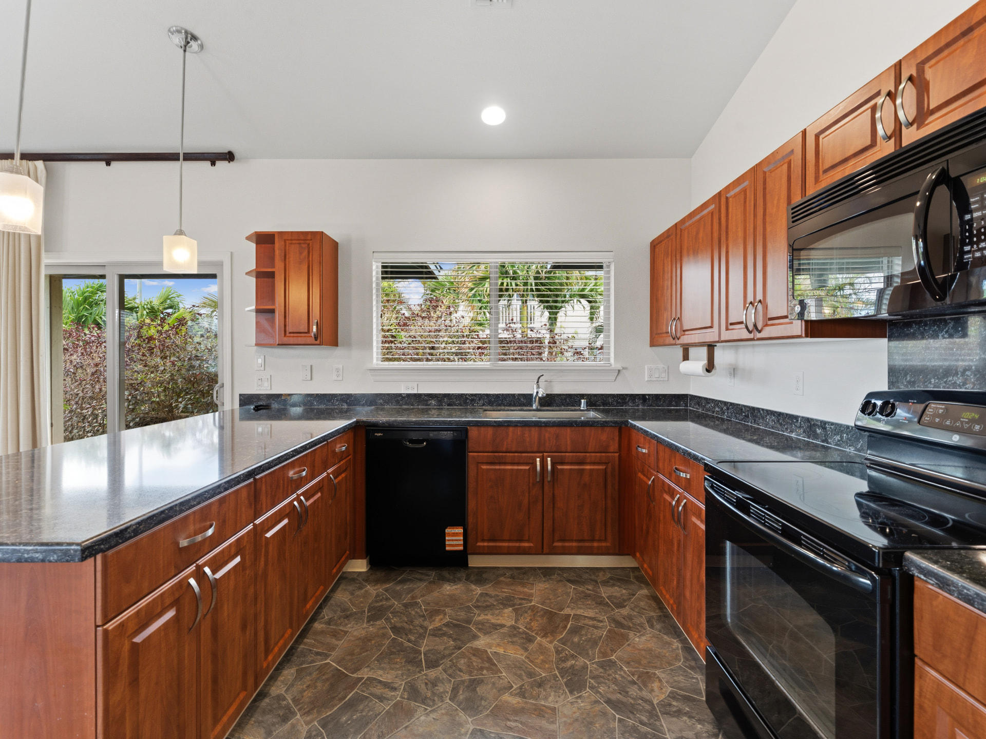 Kitchen with granite countertops, cherry cabinetry and stainless refrigerator