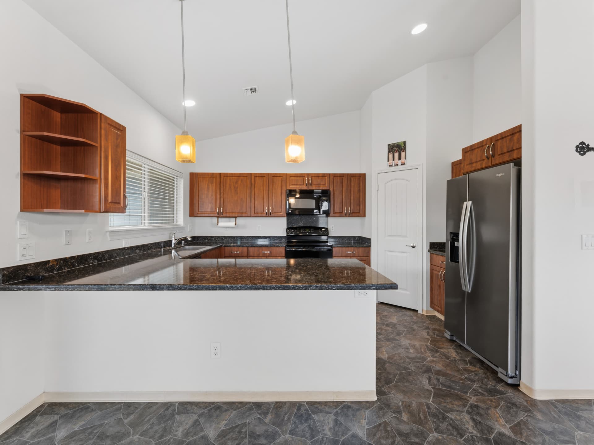 Kitchen breakfast bar with granite counters and pendant lighting