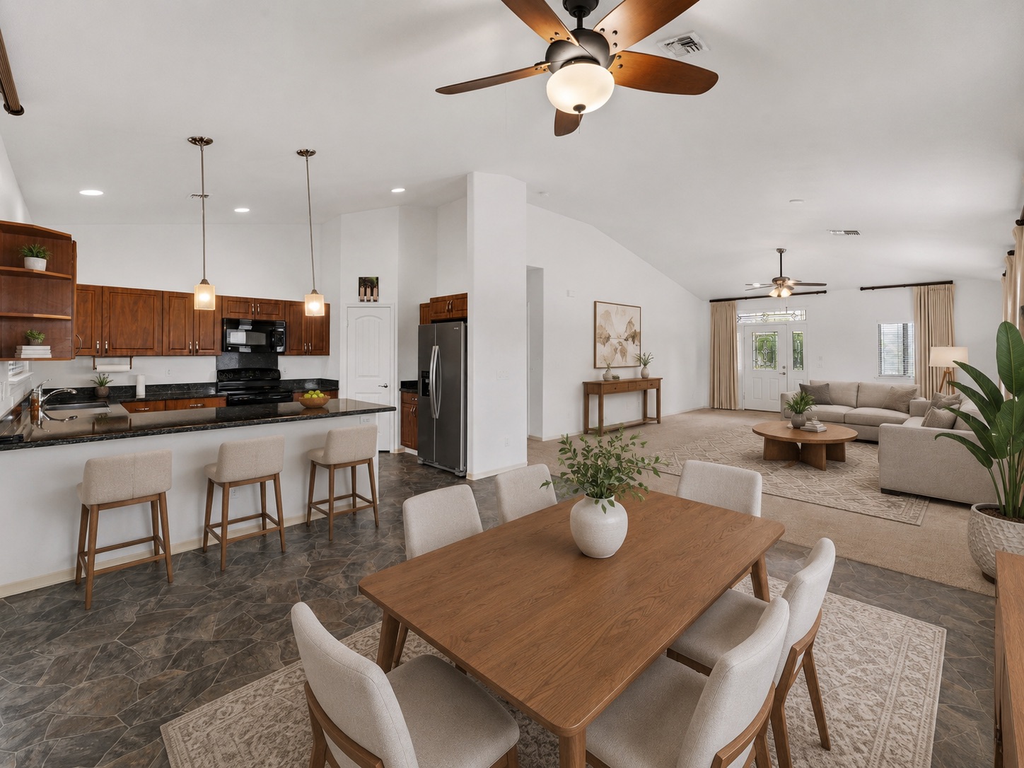 Great room showing the kitchen breakfast bar, dining table and living room in one open space