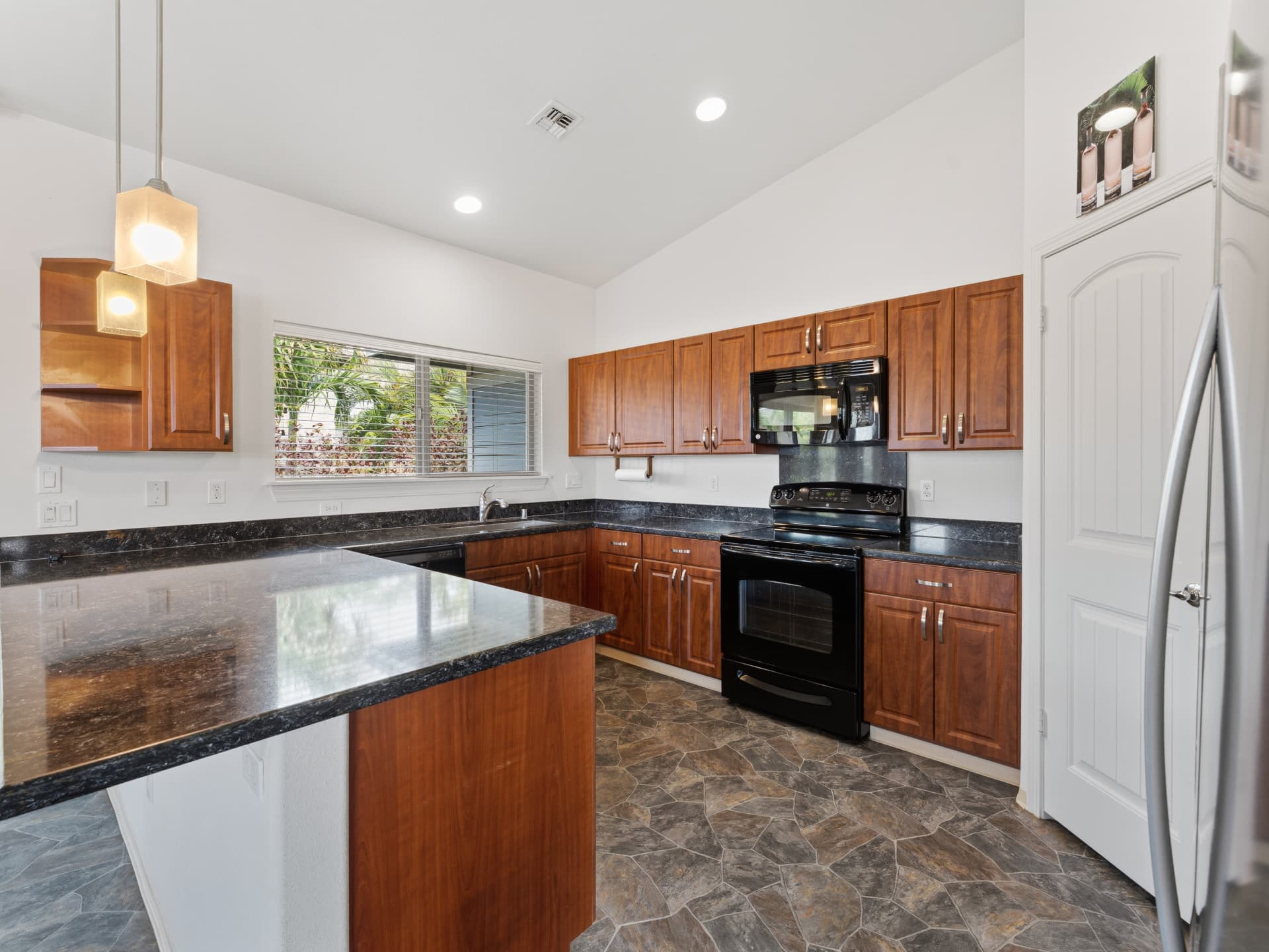 Kitchen with cherry cabinetry, granite counters and stainless refrigerator